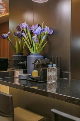 a counter with purple flowers and bottles of water at Luxury Designer Apartment Central Marrakech in Marrakech