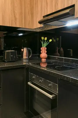 a kitchen with a stove and a vase with flowers at Luxury Designer Apartment Central Marrakech in Marrakech
