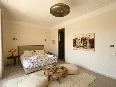 a bedroom with a bed and a table and a couch at Villa Marrazen, lovely villa -housestaff included in Marrakech