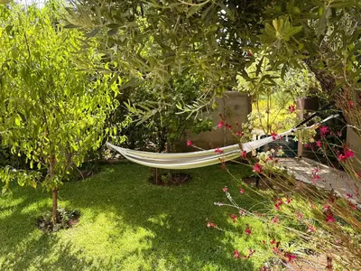 a hammock in a garden with trees and flowers at Villa Marrazen, lovely villa -housestaff included in Marrakech