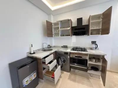 a small kitchen with a stove and a sink at Modernes Apartment in Top-Lage Guéliz, Marrakech 2 in Marrakech
