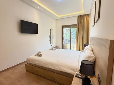 a bedroom with a bed and a television on the wall at Modernes Apartment in Top-Lage Guéliz, Marrakech 2 in Marrakech