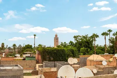 a building with a clock tower in the background at Stylish and Exclusive Riad Saada with Pool and free Breakfast in Marrakech