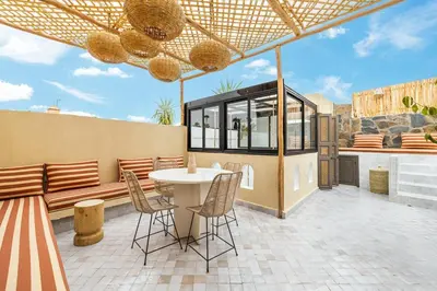 a patio with a table and chairs and a building at Stylish and Exclusive Riad Saada with Pool and free Breakfast in Marrakech