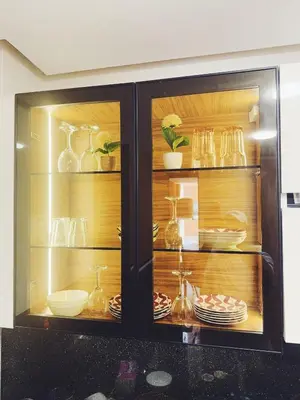 a cabinet filled with glass vases and dishes at Appartement à Marrakech in Marrakech