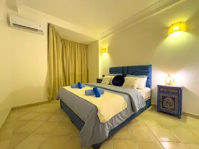 a bedroom with a large bed with blue pillows at Apart 2-Bedrooms Centre of Marrakech-Medina place in Marrakech