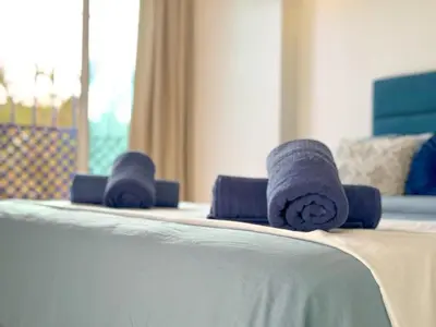 a row of blue rolled towels on a bed at Apart 2-Bedrooms Centre of Marrakech-Medina place in Marrakech