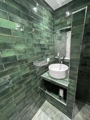 a green tiled bathroom with a sink and a mirror at Dar Farah Riad luxe privé, 3ch, piscine chauffée, ptit déj in Marrakech