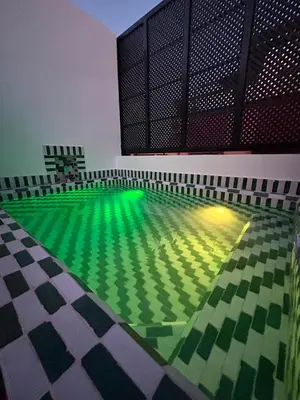 an empty pool with green water in a building at Dar Farah Riad luxe privé, 3ch, piscine chauffée, ptit déj in Marrakech