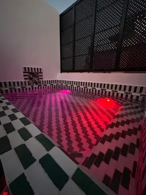 an empty swimming pool with pink lights on the floor at Dar Farah Riad luxe privé, 3ch, piscine chauffée, ptit déj in Marrakech