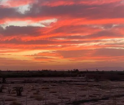 a sunset in the desert with a cloudy sky at Countryside House in Marrakech