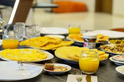a table with plates of food and glasses of orange juice at Villa R, luxury, gym, private pool in Marrakech