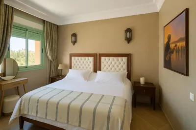 a bedroom with a white bed and a window at Bloom Hivernage Deluxe - 2 Chambres - Le Soleil en Mars - Petit déjeuner et Services de chambres inclus - A 10mn des sites - Balcon végétal in Marrakech