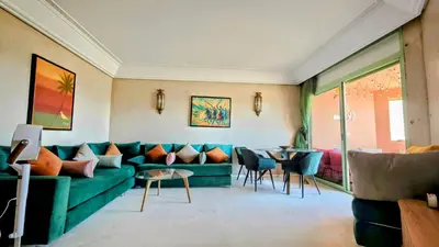 a living room with a green couch and chairs at Bloom Hivernage Deluxe - 2 Chambres - Le Soleil en Mars - Petit déjeuner et Services de chambres inclus - A 10mn des sites - Balcon végétal in Marrakech