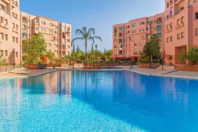 a large swimming pool in front of some buildings at Bloom Hivernage Deluxe - 2 Chambres - Le Soleil en Mars - Petit déjeuner et Services de chambres inclus - A 10mn des sites - Balcon végétal in Marrakech