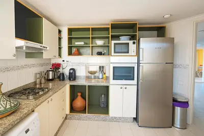 a kitchen with a stainless steel refrigerator and cabinets at Bloom Hivernage Deluxe - 2 Chambres - Le Soleil en Mars - Petit déjeuner et Services de chambres inclus - A 10mn des sites - Balcon végétal in Marrakech