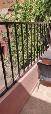 a railing on a balcony with a table and a bench at Maison tow five in Marrakech