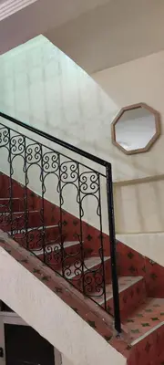 a staircase with a wrought iron railing and a window at Maison tow five in Marrakech