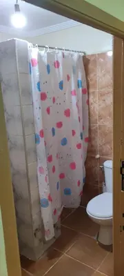 a bathroom with a toilet and a shower curtain at Maison tow five in Marrakech