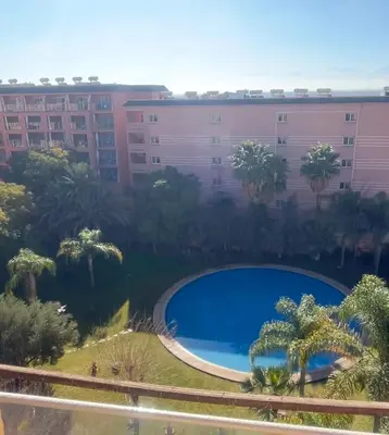 a large swimming pool in front of a building at Appartement neuf hivernage in Marrakech