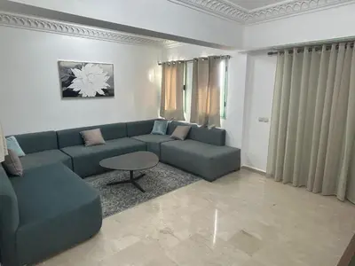 a living room with a blue couch and a table at Appartement neuf hivernage in Marrakech