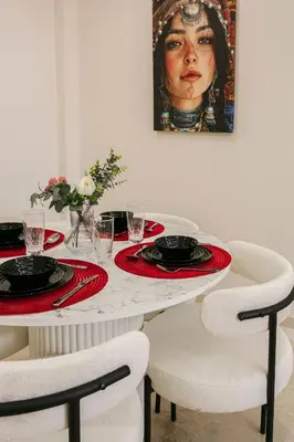 a table with two plates and a picture of a woman at Âme Berbère Piscine Privée in Marrakech