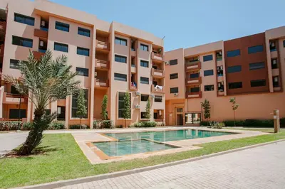 an apartment with a swimming pool in front of a building at Âme Berbère Piscine Privée in Marrakech
