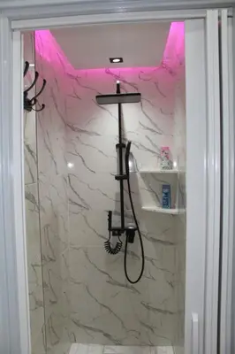 a bathroom with a shower with a stone wall at Appartement mamá MK in Marrakech