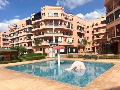a swimming pool in front of a large apartment building at Chez Mams Guest House - Private Rooms in a Resort-Style Apartment Complex in Marrakech