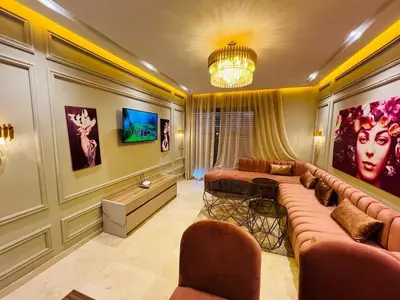 a living room with a couch and a chandelier at Perle garden in Marrakech