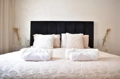 a white bed with white pillows and a black headboard at Chic & Calm in Marrakech, Ideal for Digital Nomads in Marrakech