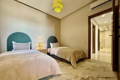 a bedroom with two beds and a hallway with a mirror at Apartment in Agdal with Pool and Terrace in Marrakech