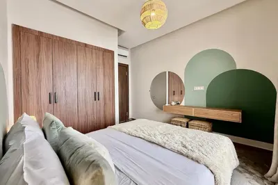 a bedroom with a bed and a green wall at Apartment in Agdal with Pool and Terrace in Marrakech