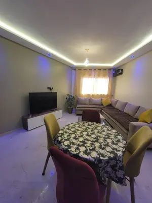 a living room with a couch and a table at Élégante Appartement au centre de Marrakech , Piscine - Parking gratuit in Marrakech