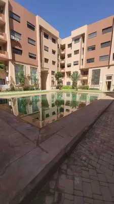 a pool of water in front of a building at Élégante Appartement au centre de Marrakech , Piscine - Parking gratuit in Marrakech