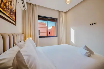 a bedroom with a white bed and a window at Un Appartement d'exception in Marrakech