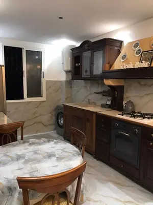 a kitchen with wooden cabinets and a table in it at Cozy Stay Central Marrakech in Marrakech