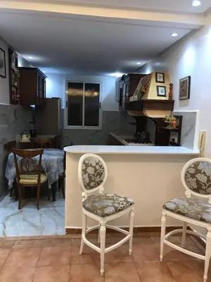 a kitchen and dining room with a counter and chairs at Cozy Stay Central Marrakech in Marrakech