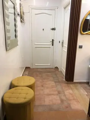 a hallway with two stools and a white door at Cozy Stay Central Marrakech in Marrakech