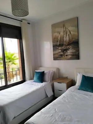 a bedroom with two beds and a painting of a sailboat at Pavillon Luxe - Jardin de l'Atlas - Golf & Waky in Sraghna