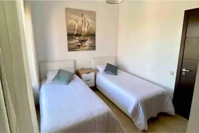 a room with two beds and a painting on the wall at Pavillon Luxe - Jardin de l'Atlas - Golf & Waky in Sraghna