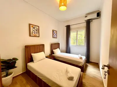 a room with two beds and a window at Appartement cosy et moderne familial in Marrakech