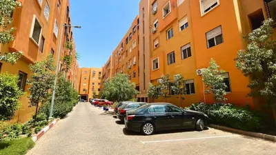 a row of cars parked in a parking lot next to buildings at Appartement cosy et moderne familial in Marrakech