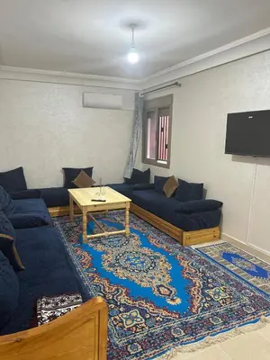 a living room with blue couches and a tv at New and nice apartment in Marrakech