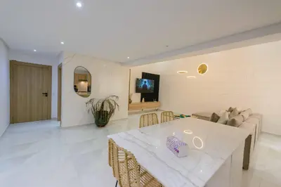 a living room with a table and a couch at Duplex d'exception - 6 personnes - tout équipé in Marrakech