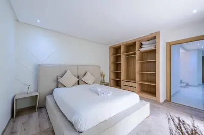 a bedroom with a large white bed and a window at Duplex d'exception - 6 personnes - tout équipé in Marrakech