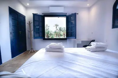 a bedroom with a large white bed with a window at Palmeraie Tradition and Modernity in Marrakech
