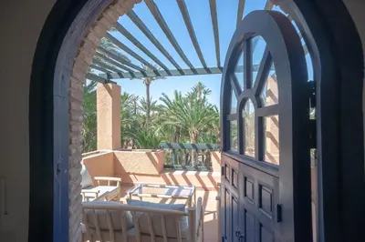 an open door to a patio with chairs and a table at Palmeraie Tradition and Modernity in Marrakech