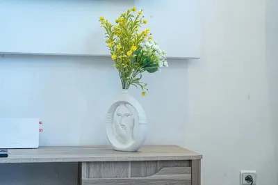 a white vase with flowers in it on a table at Palmeraie Tradition and Modernity in Marrakech