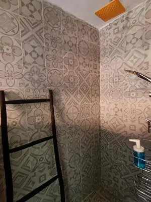 a bathroom with a shower with a patterned wall at Villa with Private Pool and Garden, Fast Wi-Fi in Marrakech